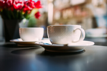 Cozy place, two cups and bouquet of fresh pink flowers