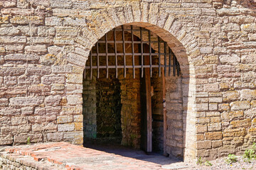 A gate with a thick metal lattice covering the entrance to the fortress