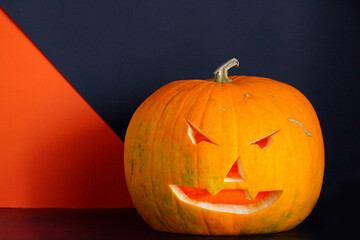 a traditional Halloween creepy carved pumpkin, with copy space on black. Halloween autumn concept