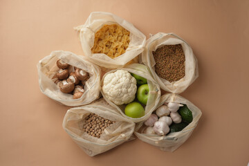 Various vegetables, pasta, mushrooms and cereals in reusable fabric eco bags. Reusable eco-friendly products. Zero waste and sustainable plastic free lifestyle. View from above.
