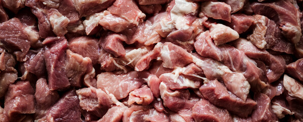 Heap of raw diced fresh beef meat isolated, top view. Banner. Pork chopped for goulash. Butcher shop concept. A raw ingredient for a lunch meal. Healthy eating. Pattern. Background. A meaty cutting