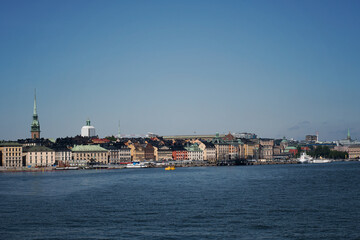 Obraz premium View of the Old Town skyline in Stockholm with the water surrounding it. Photo taken on a beautiful summer day in Sweden.