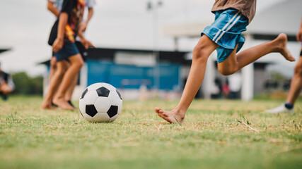 Fototapeta premium action sport outdoors of diversity of kids having fun playing soccer football for exercise in community rural area under the twilight sunset sky
