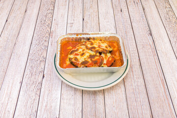 Eggplant and Parmigiana lasagna in aluminum container ready to send home to a starving customer
