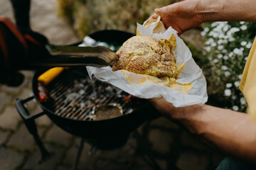 hands picking up raw steak with barbecue tongs