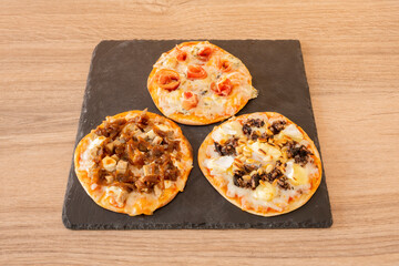 Tasting of Spanish-style pizzas with mushrooms, blood sausage, cheese, serrano ham, onion, chicken...