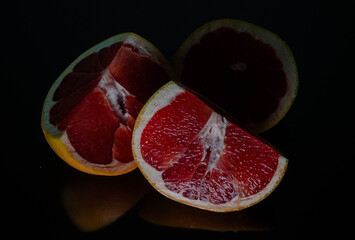 
Grapefruit, cut, three pieces, photo on a dark surface