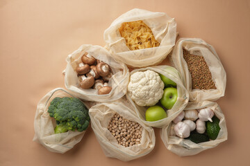 Various vegetables, pasta, mushrooms and cereals in reusable fabric eco bags. Reusable eco-friendly products. Zero waste and sustainable plastic free lifestyle. View from above.