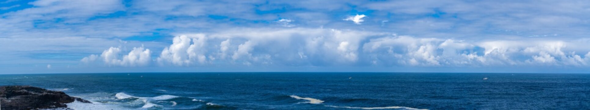 A panoramic image of Beautiful white cloud formations above the Pacific ocean near Depoe Bay on the Central Oregon coast