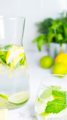 Decanter and glass with lemon, lime and mint drink. Image with selective focus