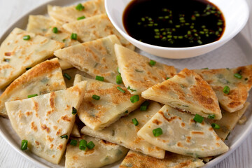 Homemade Scallion Pancakes with Soy Dipping Sauce on a white wooden background, side view. Close-up.