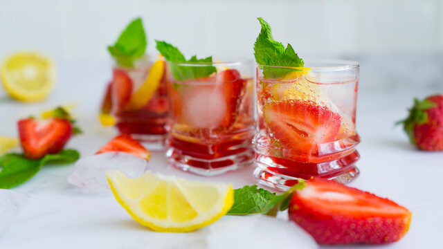 Refreshing drinks with strawberries, lemon, ice and mint. Image with selective focus