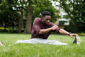 Portrait of black male stretching in a park. - Powered by Adobe