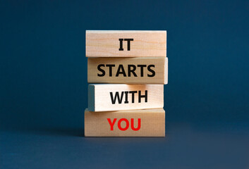 It starts with you symbol. Wooden blocks with words 'it starts with you' on beautiful grey...