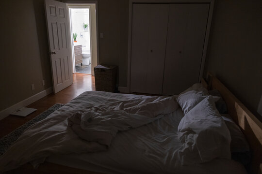 Unmade Bed In Dark Bedroom