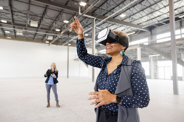 Realtor showing warehouse to client using VR headset