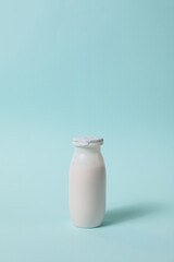 Bottle with probiotics and prebiotics dairy drink on light blue background.