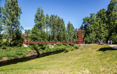 Red bridge over the Tosna River in the manor of Maryino-the former noble estate of Counts Stroganov and Princes Golitsyn. Leningrad Region, Russia