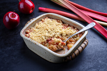 Traditional English crumble cake with rhubarb and apple with backed topping served as close-up in...