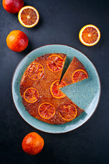 Modern style traditional Italian blood orange ricotta pie with fruits and almonds served as close-up on a Nordic design plate with copy space