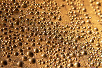 Drops of water on the golden surface. Abstract background