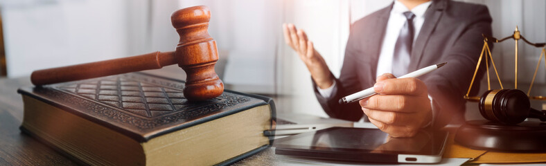 Business and lawyers discussing contract papers with brass scale on desk in office. Law, legal services, advice, justice and law concept picture with film grain effect