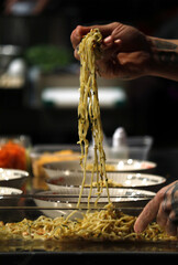 chef probando su plato de espaguetis cogiéndolo con palitos