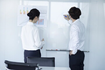 Naklejka premium Businessman Explaining and Pointing at Chart on Board
