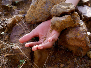 Boy hand presented down the stone rocks, land slide concept.