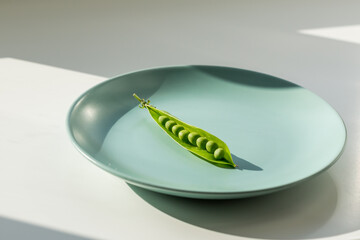 One fresh ripe sweet pea on the green plate. Healthy lifestyle concept.
