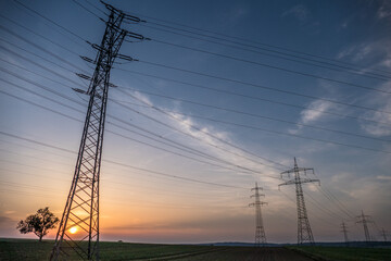 Strommasten einer Überlandleitung bei Sonnenuntergang