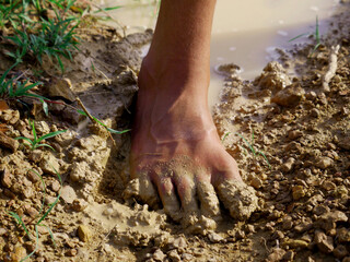 male foot on mud presented agriculture concept.