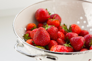 Fresh red ripe organic strawberry in the white steel bowl. Healthy vegan food.