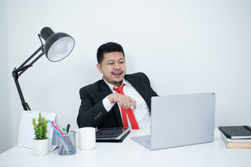 Young, happy businessman is working in his office.