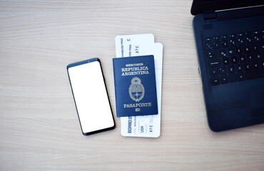 Argentine passport and boarding pass with smartphone with copy space on wooden table
