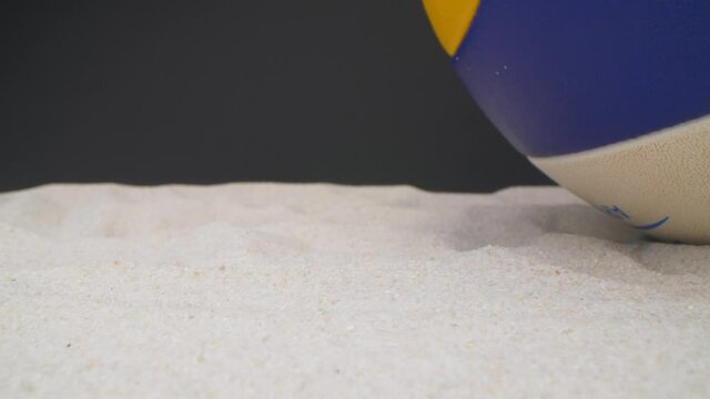 Close up view of beach sand and volleyball ball. Summer games during vacation. Probe lens.