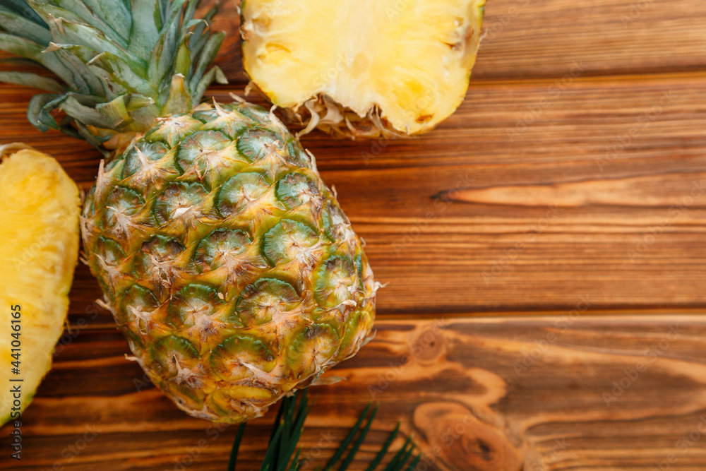 Wall mural ripe pineapple. tropical summer fruit pineapple sliced and whole pineapple on a wooden brown dark ta