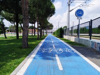 blue bicycle path between the park and the railway