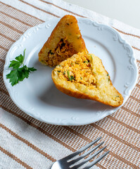 Coxinha, traditional snack of Brazilian cuisine stuffed with chicken, isolated on white background. Cut in half