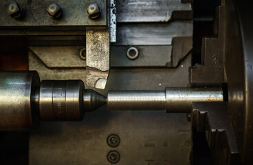 Mechanical processing of metal on a lathe, close-up. The steel bar is clamped in the lathe and the cutter is brought in. 