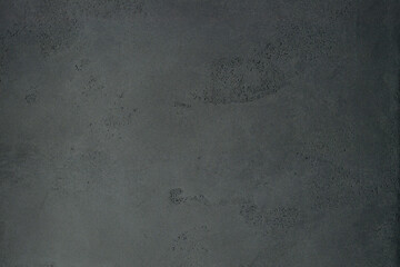 Texture of a dark concrete wall with pores and dents. Made of mini cement.