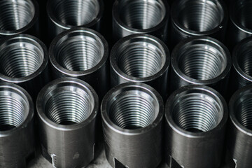 Even rows of steel threaded circular sleeve bearings put closely together. Close up.
