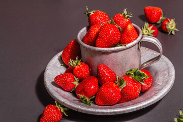 Concept of summer food with a strawberry on a black stone background
