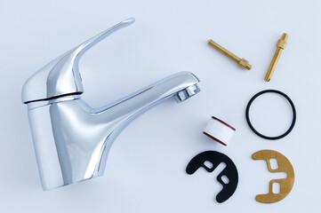 Plumbing chrome faucet and fixing set with gasket on white background.
