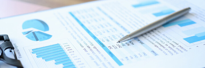 Obraz premium Clipboard with financial report and pen lie on table