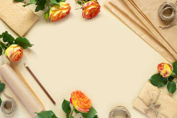 Gifts in paper wrapping, set of vintage yellow package paper, rolls, ropes and pencils for decoration. Bouquet of yellow roses on yellow vintage background.