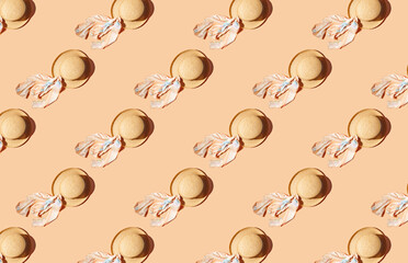 Pattern of straw with ribbon hats on orange pastel background