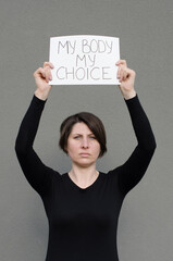 Woman showing protest banner with the message my body my choice. Right to abortion. Human rights freedom. Stop discrimination. - obrazy, fototapety, plakaty