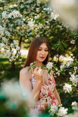 Portrait of a beautiful cute girl in blooming apple orchards