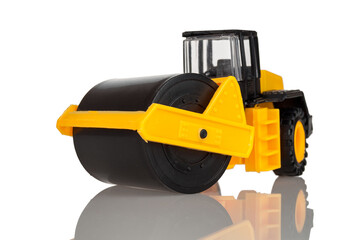 Obraz na płótnie Canvas Children's toy road construction roller, vibroroller, asphalt paver, isolated on a white background, close-up